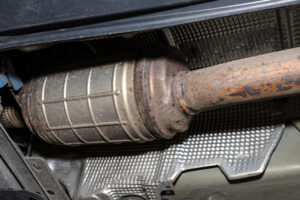 A diesel particulate filter in the exhaust system in a car on a lift in a car workshop